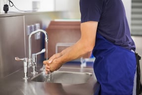 Man testing hand washing water temperature 